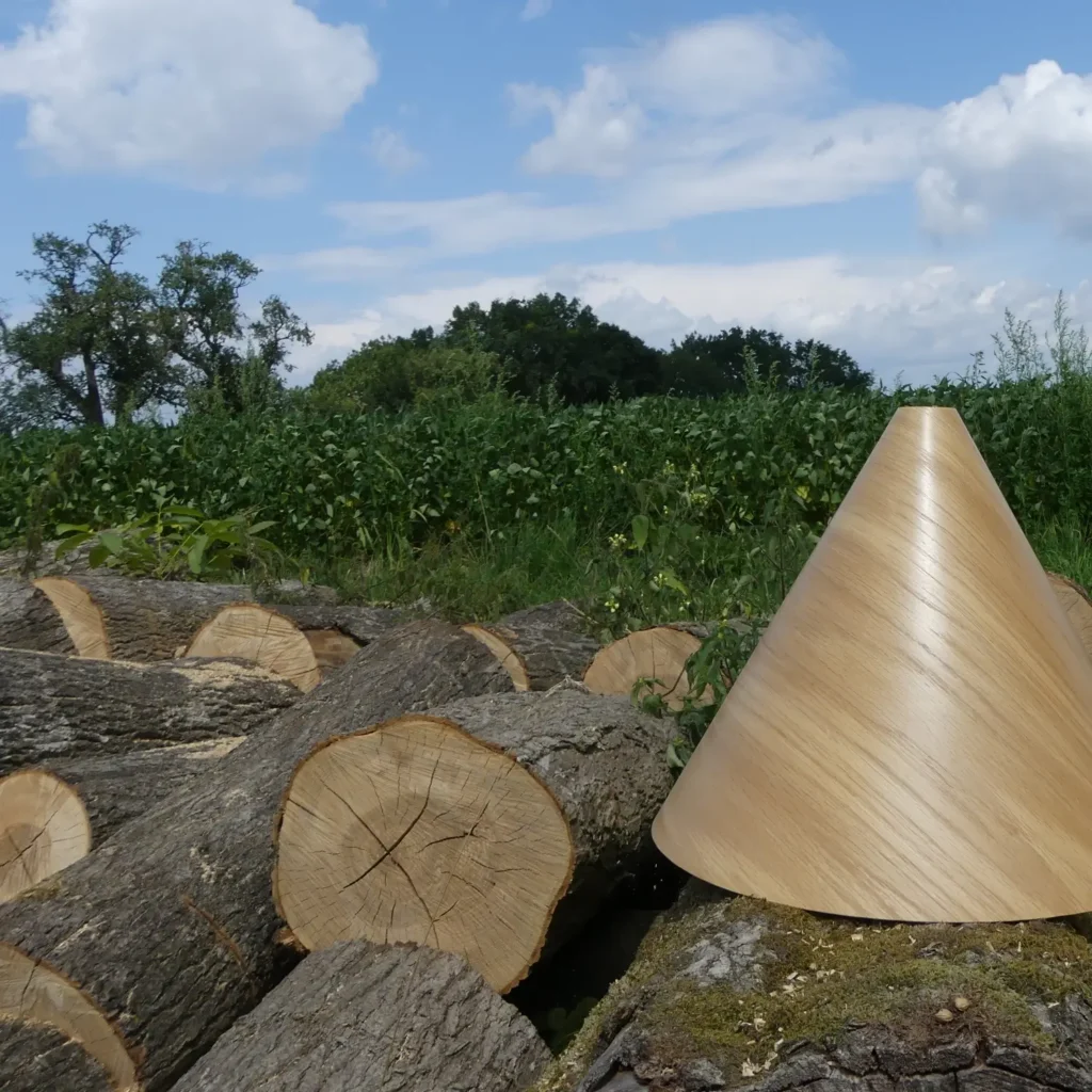 Die Pendelleuchte aus Eichenholz auf einem Holzstoß